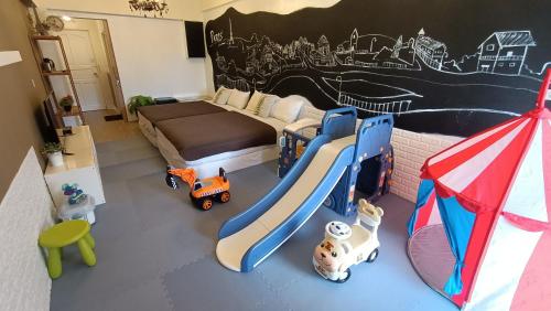 un dormitorio con una cama y algunos juguetes en ella en 仲夏墾丁親子民宿, en Nanwan