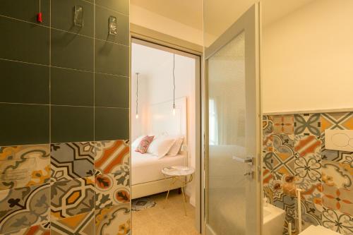 a bathroom with a shower and a bedroom at CasAunoE Boutique Hotel in Olbia