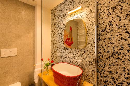a bathroom with a red stool and a mirror at CasAunoE Boutique Hotel in Olbia