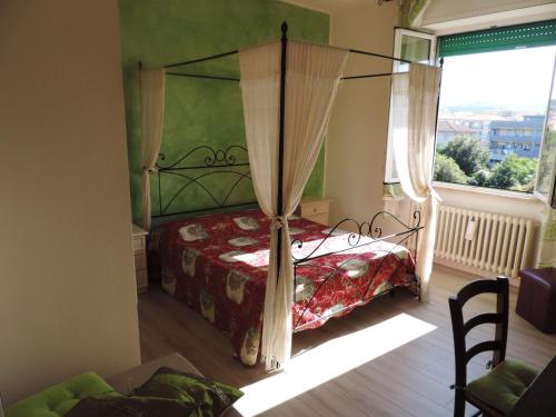 1 dormitorio con cama con dosel y ventana en Noemi, en San Vincenzo