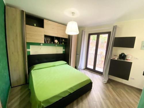 ein grünes Bett in einem Zimmer mit Fenster in der Unterkunft La Casa del Poeta in Taormina