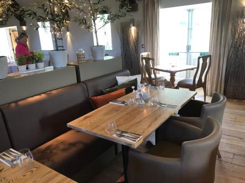 a dining room with a wooden table and chairs at The Farmhouse at Bodnant Welsh Food in Conwy