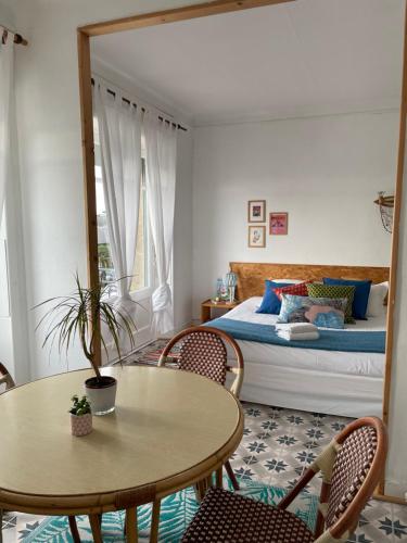 une chambre avec un lit, une table et des chaises dans l'établissement L´arrière Cour, à Cancale