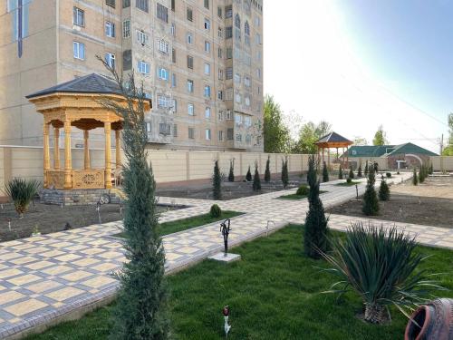 a garden with a gazebo in front of a building at Panjakent Plaza in Panjakent