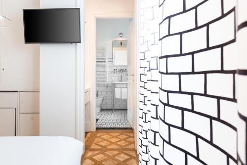 Sleep B&B في فولونيكا: غرفة نوم بجدار أبيض مع تلفزيون