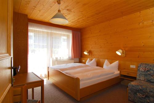 um quarto com uma cama grande e uma janela em Zillertal Apartments em Hippach