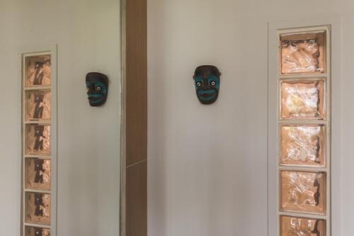 two masks hanging on a wall next to a window at 貳樓居 in Shanhua