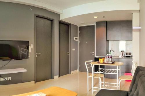 a living room with a table and a kitchen at Lovina 16-AE at One Residence(near Ferry Terminal) in Batam Center