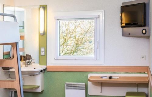 ein Bad mit einem Waschbecken und einem Fenster in der Unterkunft ibis Budget Rostock Broderstorf in Rostock