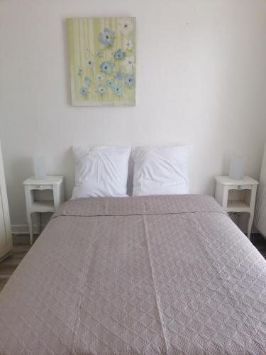 una camera da letto con un grande letto con due tavoli bianchi di arcueil ad Arcueil