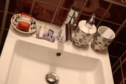 lavamanos con 2 tazas y cepillo de dientes en Suite&B, en Scicli