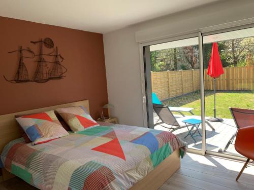 - une chambre avec un lit et une terrasse avec une porte coulissante en verre dans l'établissement Gites La Baie des Remparts Meublé Le Hâble d'Ault, à Ault