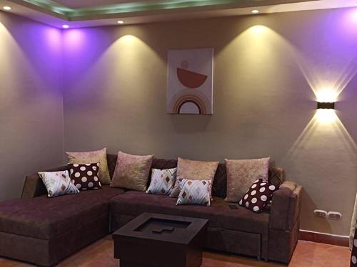 a living room with a brown couch and purple lights at العين السخنة بورتو الاهرامات عائلات فقط in Ain Sokhna