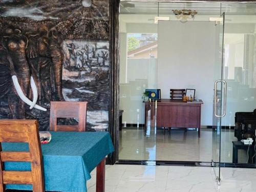 a room with a table and a wall with an elephant mural at Funwhales Rest House in Negombo