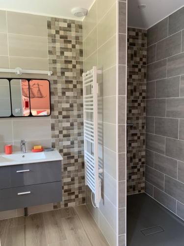 une salle de bain avec un lavabo et une douche dans l'établissement Gites La Baie des Remparts Meublé Le Hâble d'Ault, à Ault