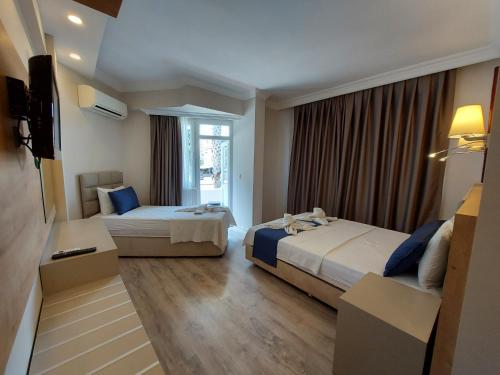 a hotel room with two beds and a television at Afsin Hotel in Antalya