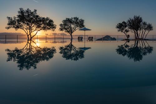 凱里翁的住宿－Artina Luxury Villa，日落时分水中树木的反射