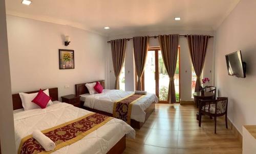 a hotel room with two beds and a window at Reaksmey Meanrith Guesthouse and Residence in Sihanoukville