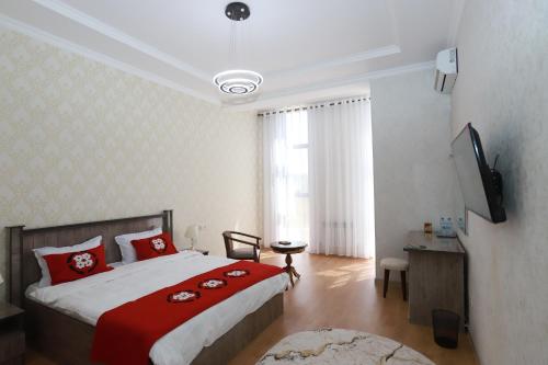 a bedroom with a large bed with red pillows at Panjakent Plaza in Panjakent