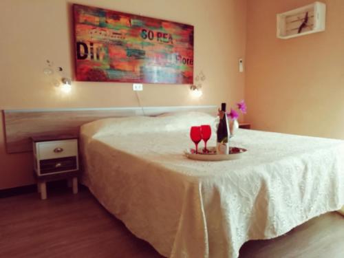 Pokój z łóżkiem ze stołem i 2 kieliszkami do wina w obiekcie Hotel Eva La Romantica w mieście Moneglia
