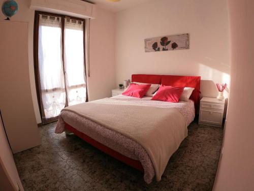 Il Canto degli Uccelli في Roccamorice: غرفة نوم بسرير كبير ومخدات حمراء