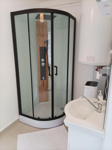 une douche en verre dans une salle de bain avec un lavabo dans l'établissement O'Couvent - Appartement 54 m2 - 1 chambre - A301, à Salins-les-Bains