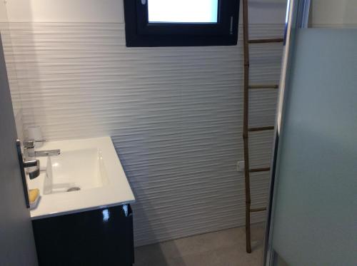 une salle de bain avec un lavabo et une fenêtre dans l'établissement COQUET APPARTEMENT INDÉPENDANT DANS VILLA ENTRE MER ET MONTAGNE, à Sotta