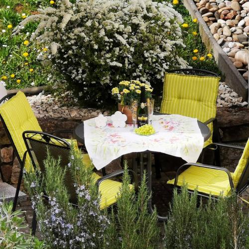 einen Tisch mit 2 Stühlen und einen Tisch mit Blumen in der Unterkunft Ferienwohnung Subat in Ettenheim