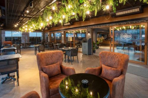 a lobby of a restaurant with chairs and tables at Luxon Hotel Sakarya in Serdivan