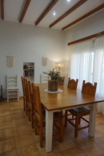 uma sala de jantar com uma mesa de madeira e cadeiras em CASA REME em Navarrés