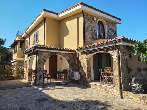 a large house with a balcony and a patio at B&B Brezza di Mare (Sea Breeze) in Villasimius