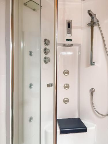 a shower with a glass door next to a sink at Pension As Burgas Ii in Caldas de Reis