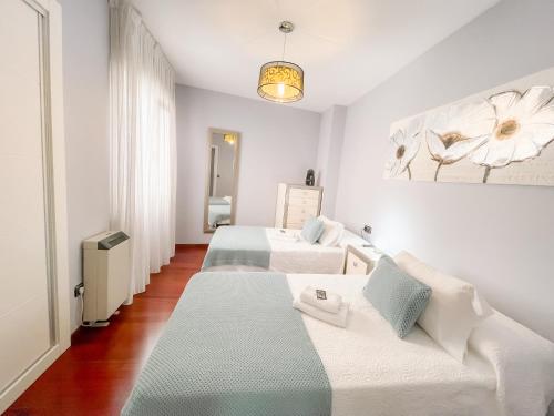 カルダス・デ・レイスにあるPension As Burgas Iiのベッド2台とソファが備わるホテルルームです。