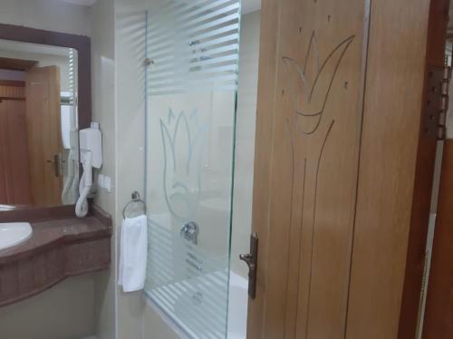 baño con ducha y puerta de cristal en Town View Hotel en El Cairo