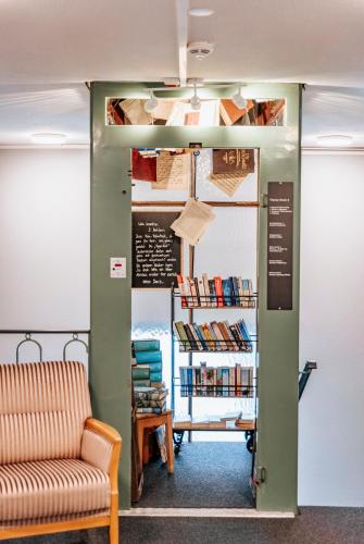 a room with a couch and a shelf of books at Emma's B&B - Self Check-in Hotel in Lungern