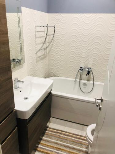 a bathroom with a sink and a tub and a toilet at Swiss Central Luxury Apartment 132m2 in Sarajevo