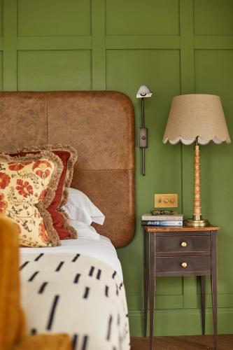 a bedroom with green walls and a bed with a lamp at Rothay Manor Hotel in Ambleside