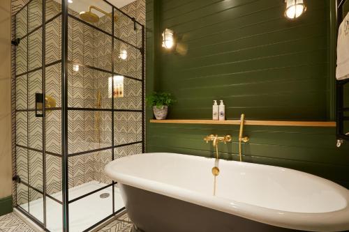 a bath tub in a bathroom with green walls at Rothay Manor Hotel in Ambleside