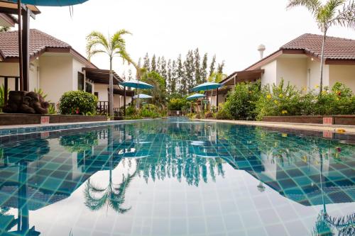 una piscina di fronte ad alcune case di Pinnacle Grand Jomtien Resort and Beach Club - SHA Extra Plus a Na Jomtien