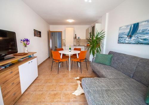 sala de estar con sofá y mesa con sillas en Apartmant Linda en Vinkuran