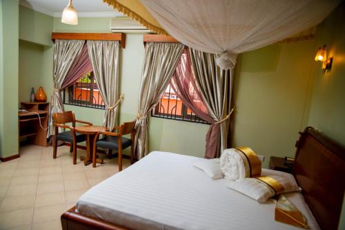una camera con letto, scrivania e finestra di Lush Garden Business Hotel ad Arusha