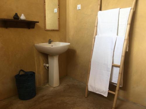 a bathroom with a sink and a towel rack at MKS - Kite & Wing Foil camp in Kalpitiya