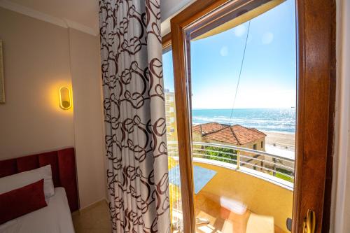 a room with a window with a view of the ocean at Hotel Vila Misiri in Durrës