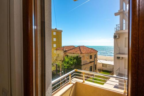 a window with a view of the ocean from a building at Hotel Vila Misiri in Durrës