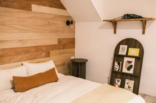 a bedroom with a bed and a wooden wall at South Gate Home Stay in Tainan