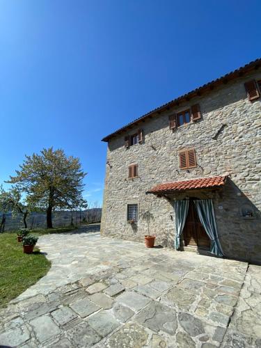 un gran edificio de piedra con un patio de piedra en IL CASALE di ROLANDO, en Castiglione di Garfagnana