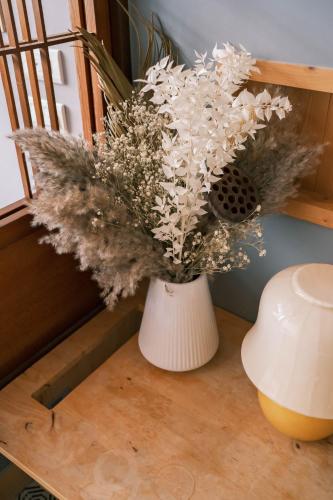 a vase filled with white flowers sitting on a table at South Gate Home Stay in Tainan