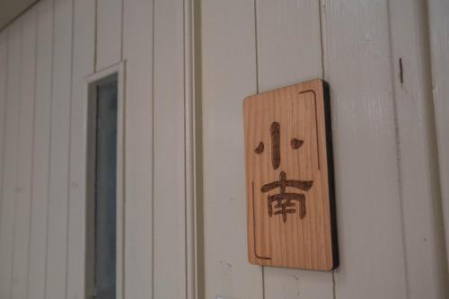 a wooden switch on a wall with an asian sign at South Gate Home Stay in Tainan