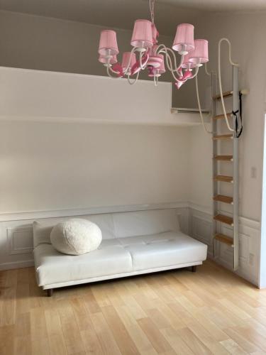 Sofá blanco en una habitación con iluminación rosa en SASAKOJIMA cottage, en Kure