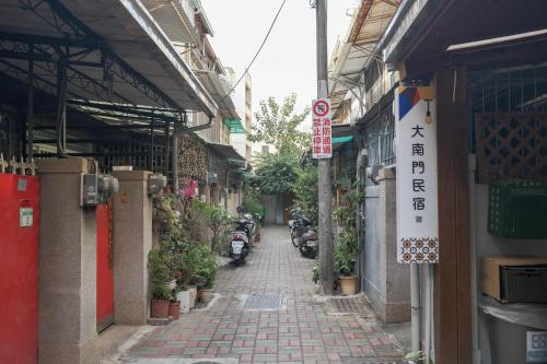 an alley in an asian city with motorcycles parked at South Gate Home Stay in Tainan